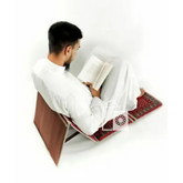 Man leest op een klapstoel met gebedskleed en rugleuning voor gebed of meditatie